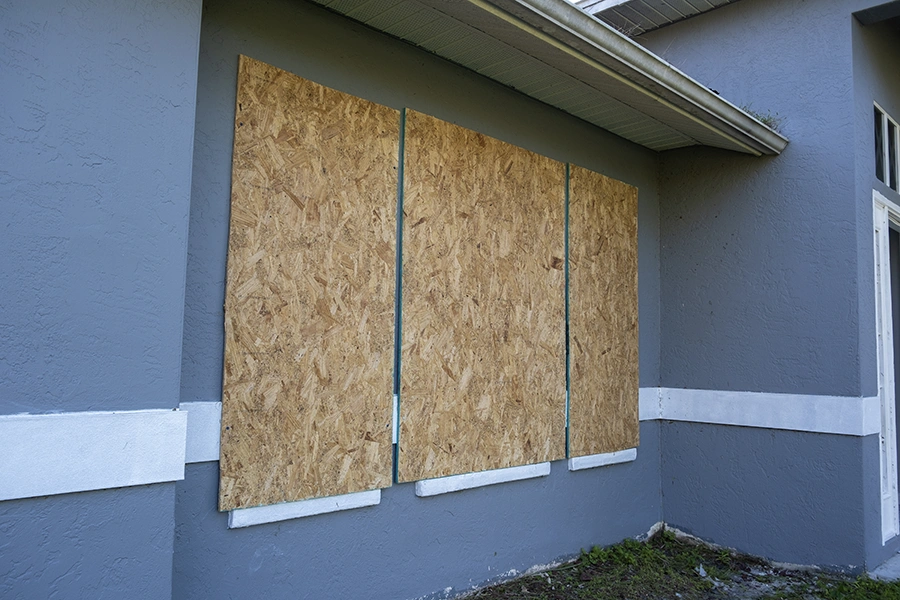 Hurricane shutters made from plywood mounted for protection of house windows.
