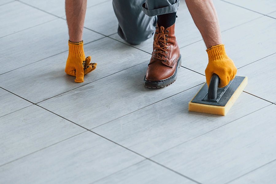 man cleaning tile and grout flooring