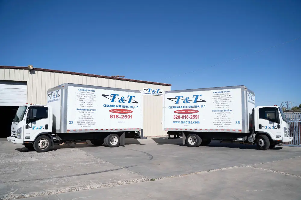 Two T&T Cleaning & Restoration box trucks parked at the Tucson facility
